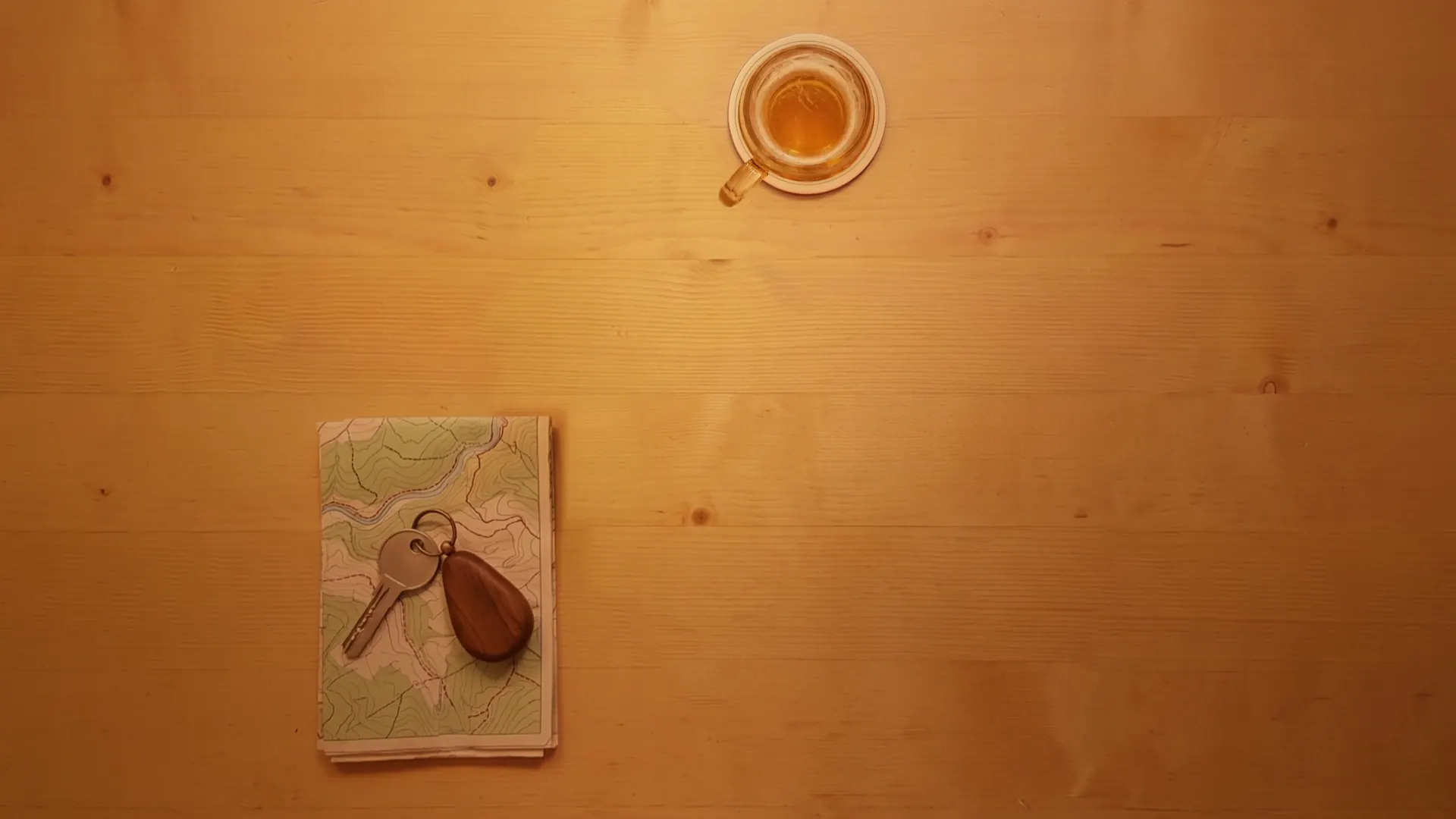 Derselbe Tisch im warmen Abendlicht, das Bierglas ist halb leer, Karte und Schlüssel liegen bereit.